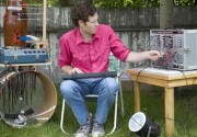 Chad Vangaalen playing a bunch of instruments in a yard
