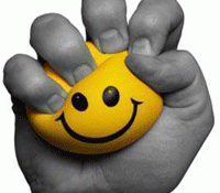 Photo of hand squeezing a yellow happy face stress ball