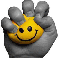 Photo of hand squeezing a yellow happy face stress ball 